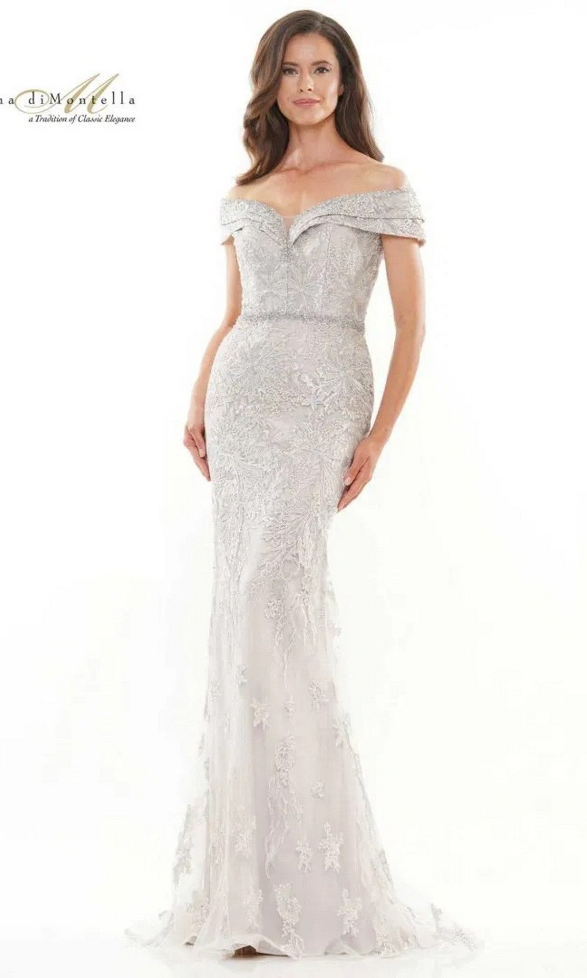 A woman models the Rina Di Montella RD2737 long formal dress in light mauve, featuring an off-the-shoulder sheer lace gown with floral embroidery and a beaded waist, standing against a plain white background.